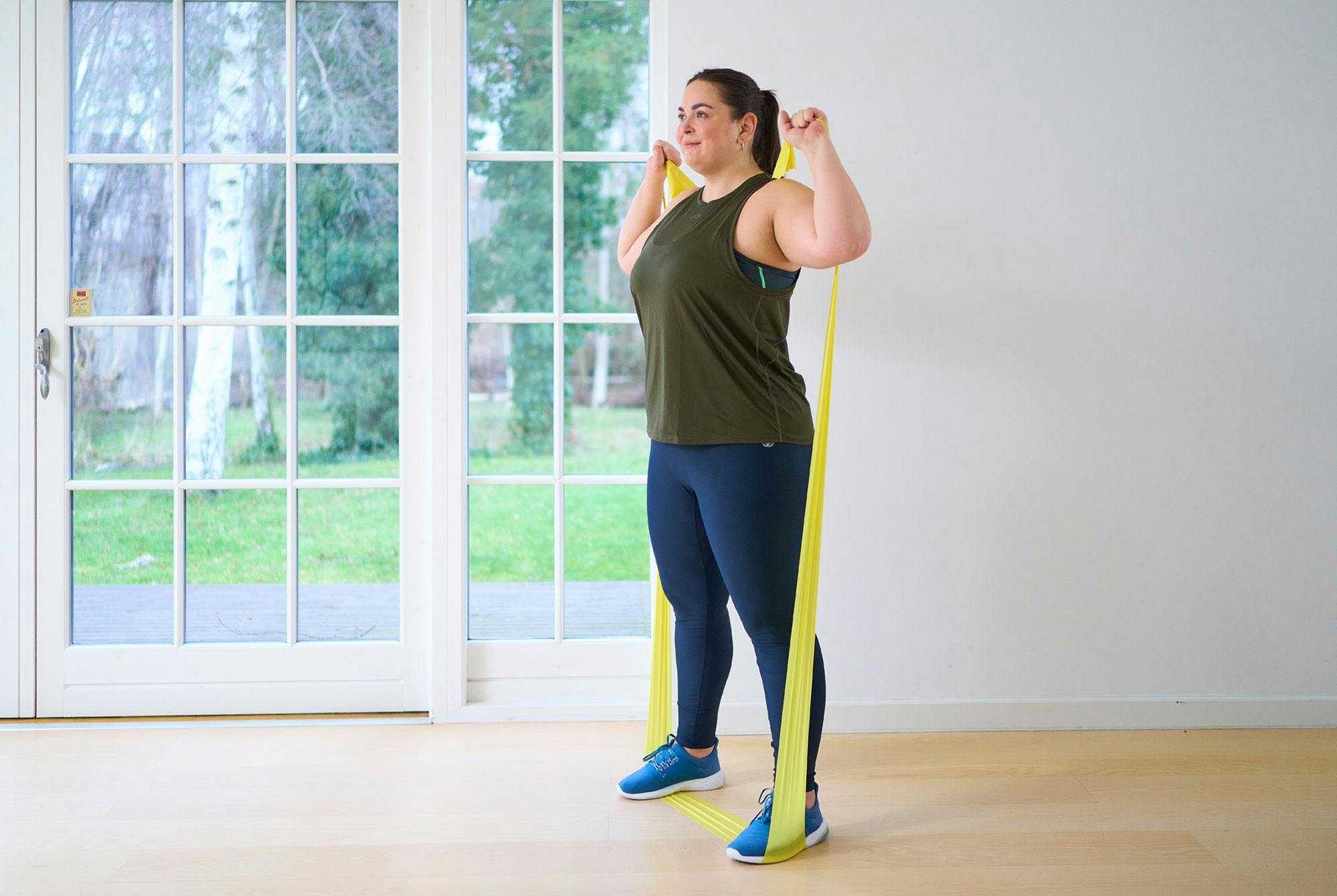kvinna gör squat med gummiband