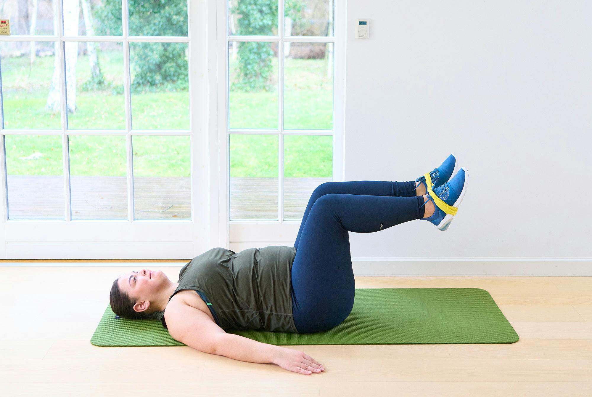 Kvinna gör psoas march med gummiband