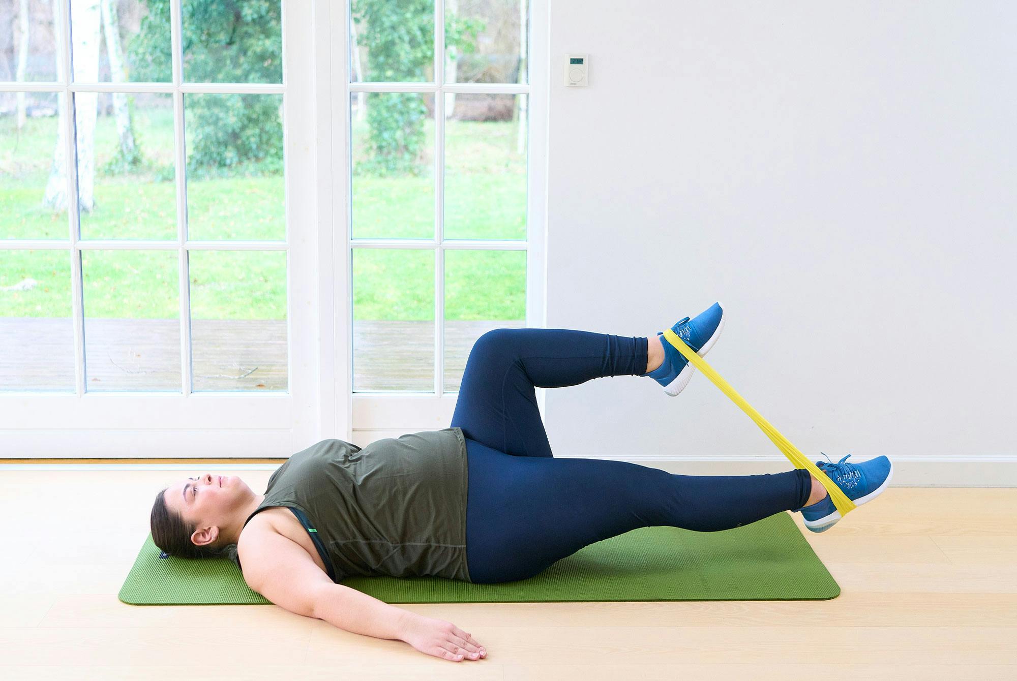 Kvinna gör psoas march med gummiband