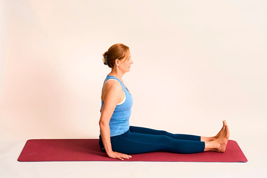 nainen tekee joogaharjoitetta selän kierto istuen