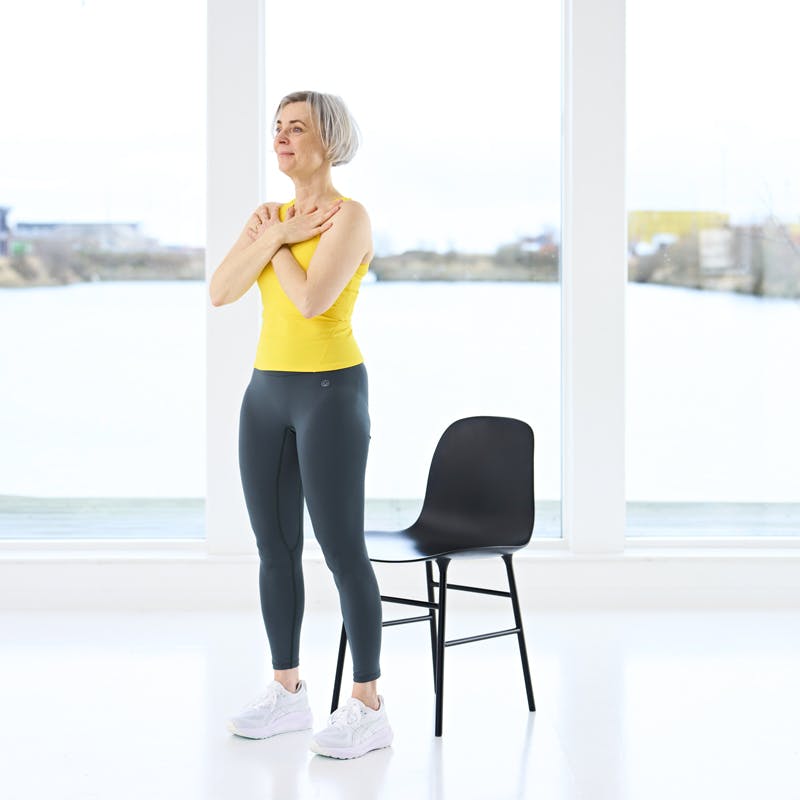 Kvinde står foran stol, RSS