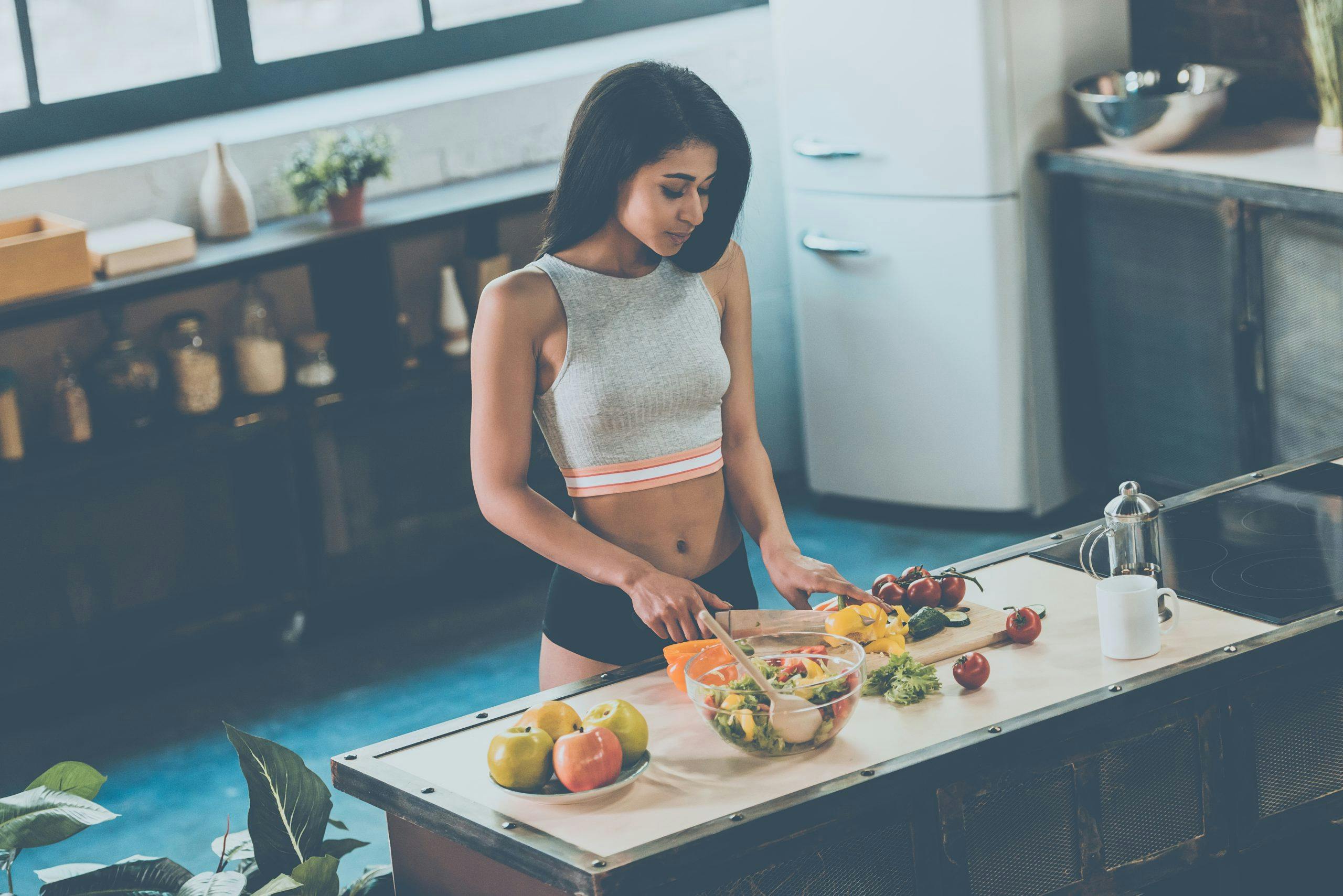 Kvinde forbereder sund mad i køkkenet
