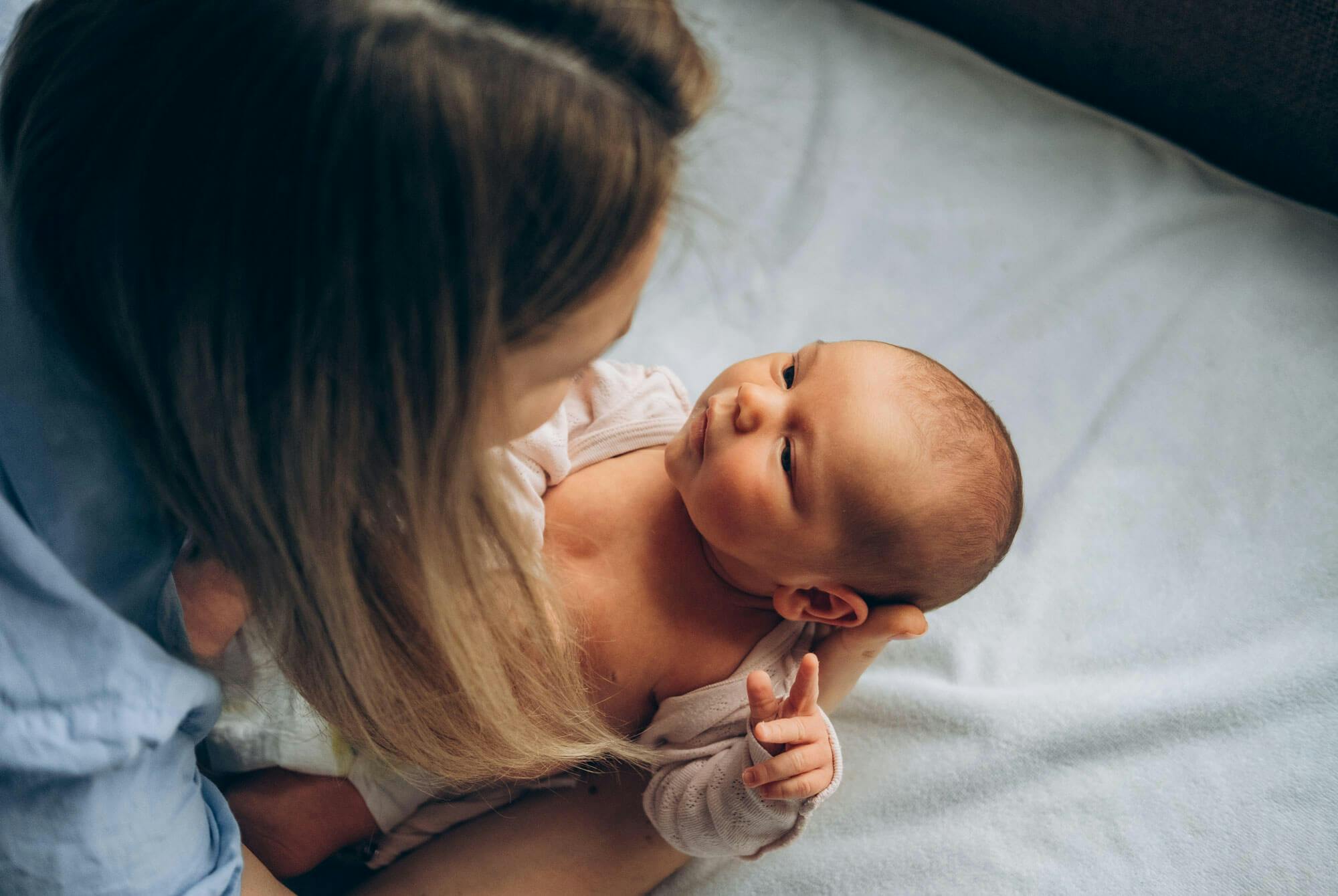 Kvinna med liten bebis - östrogen toppar runt den fertila åldern