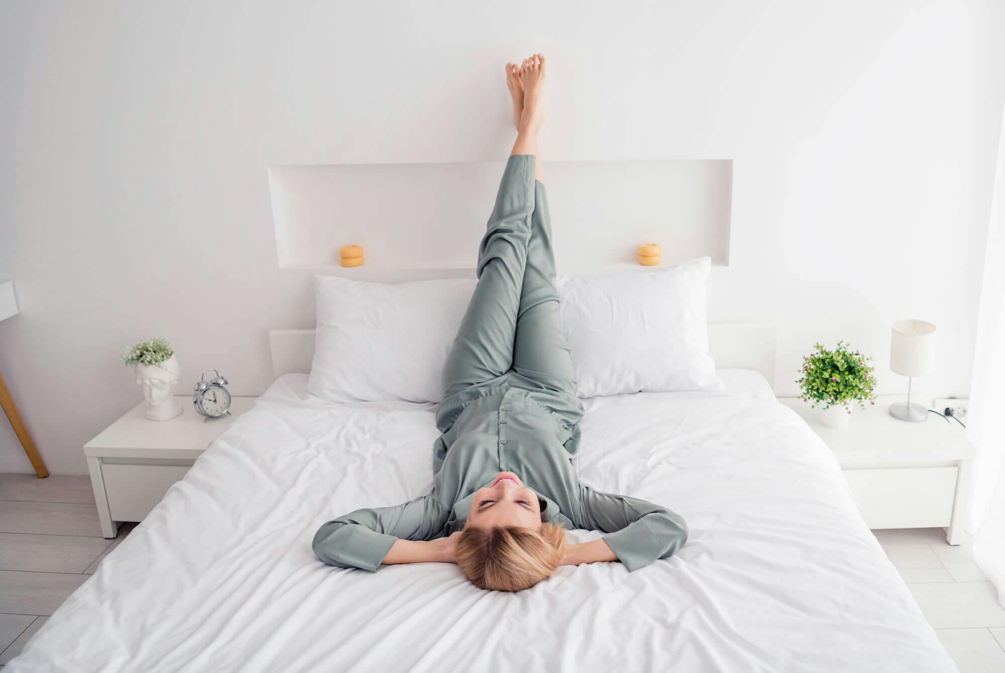 Kvinne i sengen med beina i været for å hindre vannansamlinger