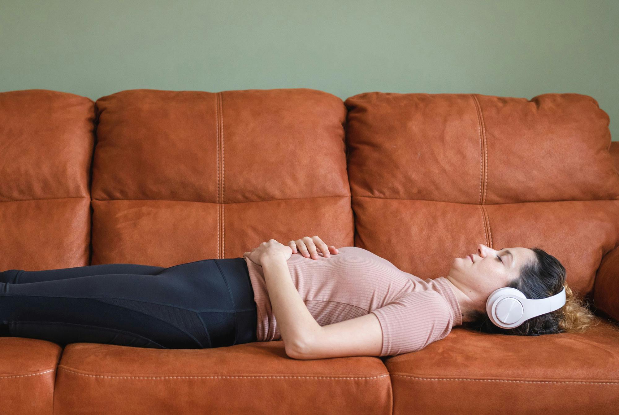 nainen rentoutuu sohvalla saadakseen sykkeen alas