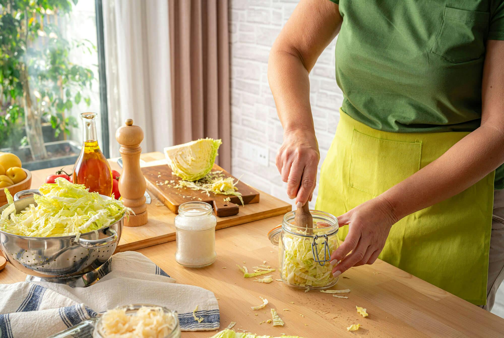 kvinna skär vitkål till surkål