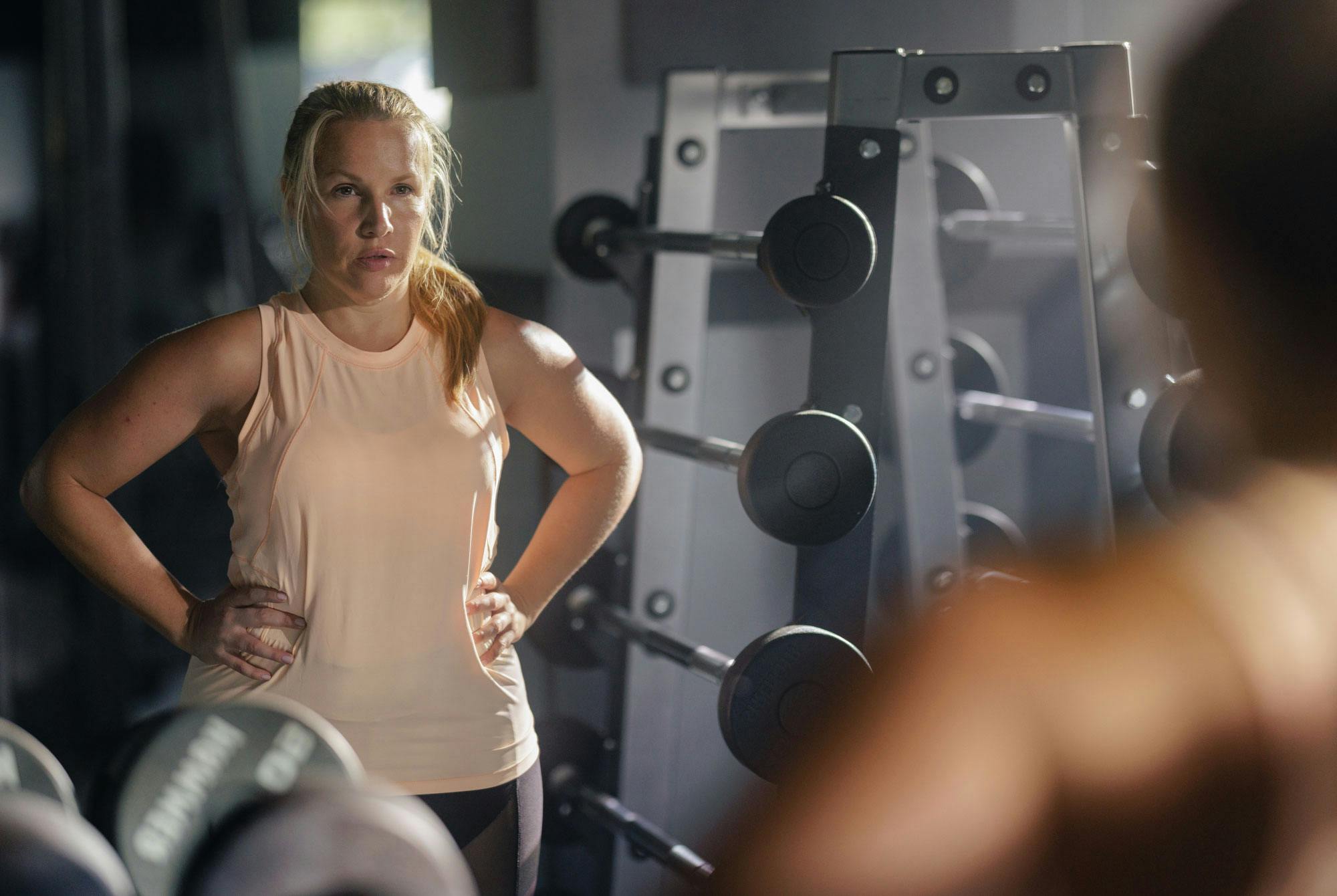 Kvinna på gymmet tittar i spegeln – midjemått