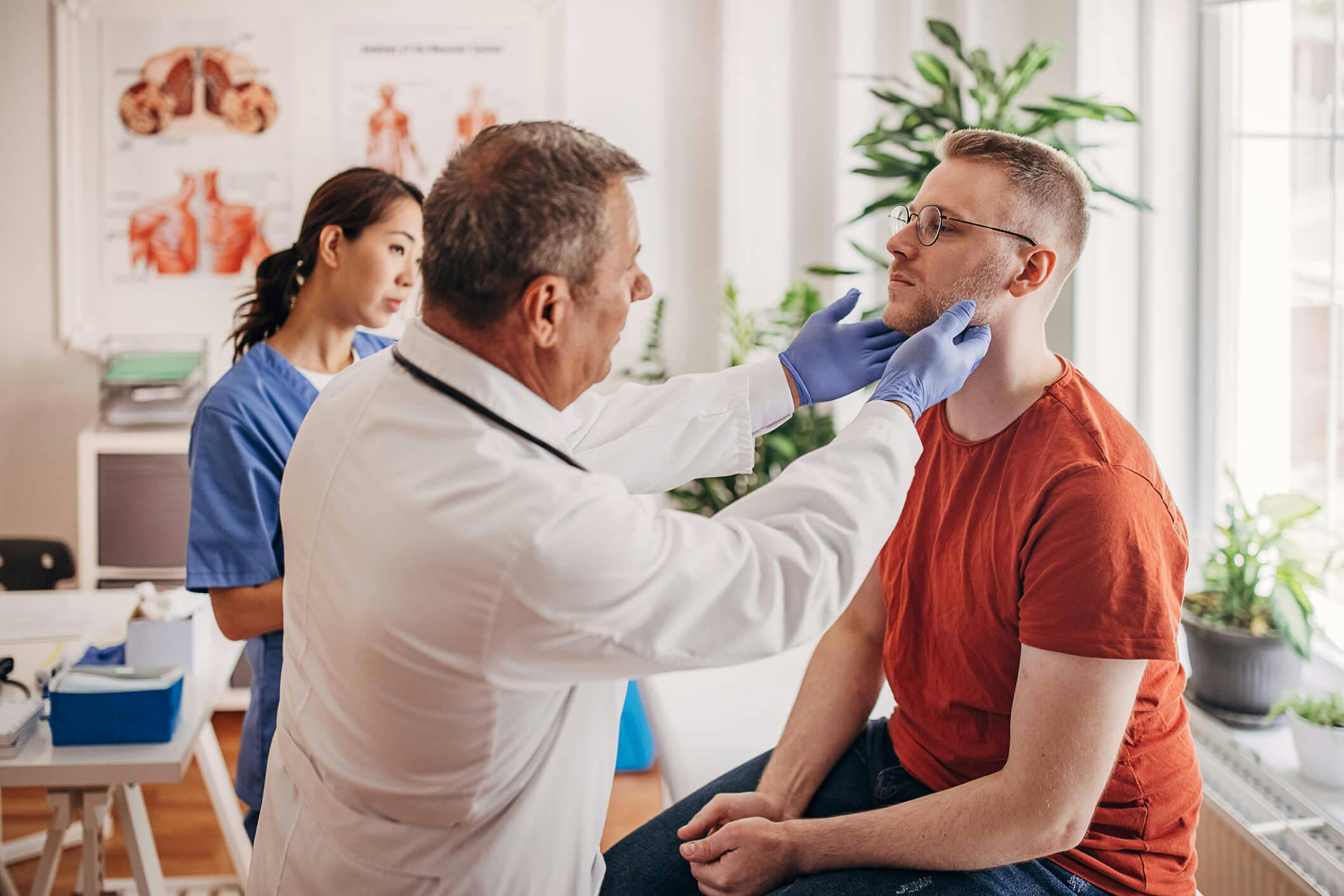 Lääkäri tutkii kurkkukivusta kärsivää potilasta.