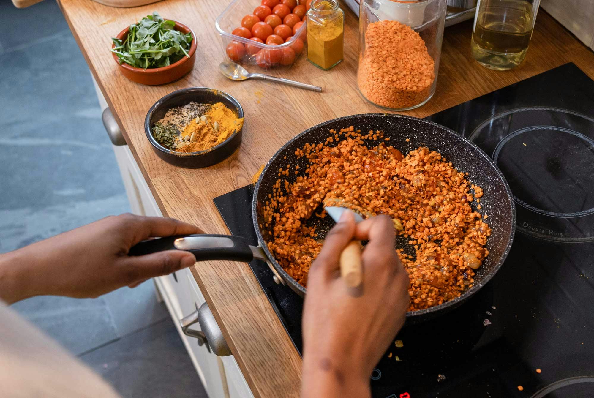 kvinde laver linsegryde ved komfur