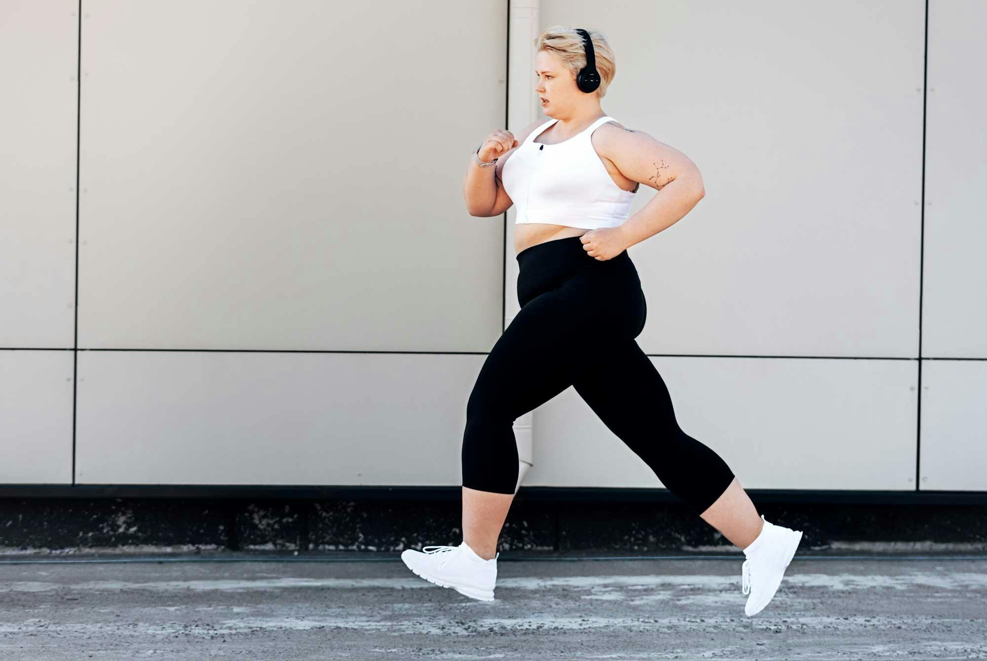 Overvektig, glad kvinne ute og trener og går tur - god trening for vekttap