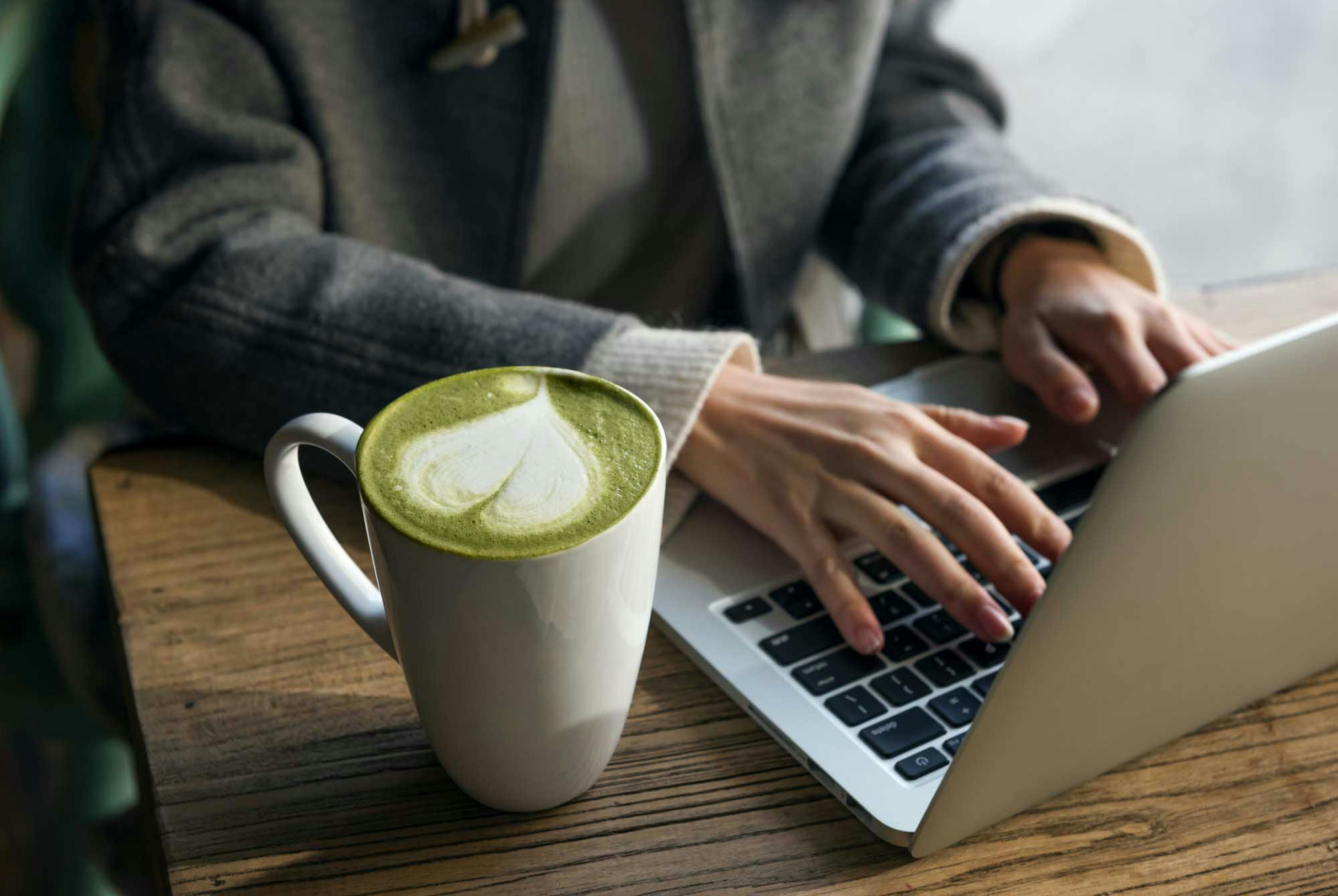 kvinde drikker matcha te på jobb