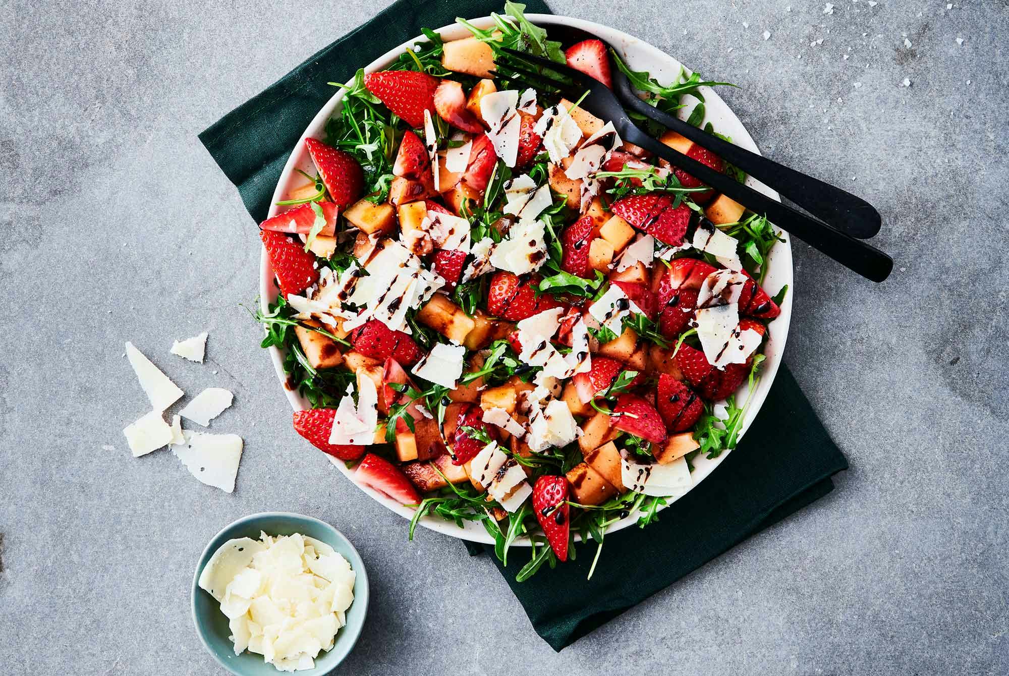 Skål med salat av jordbær, ruccola og parmesan