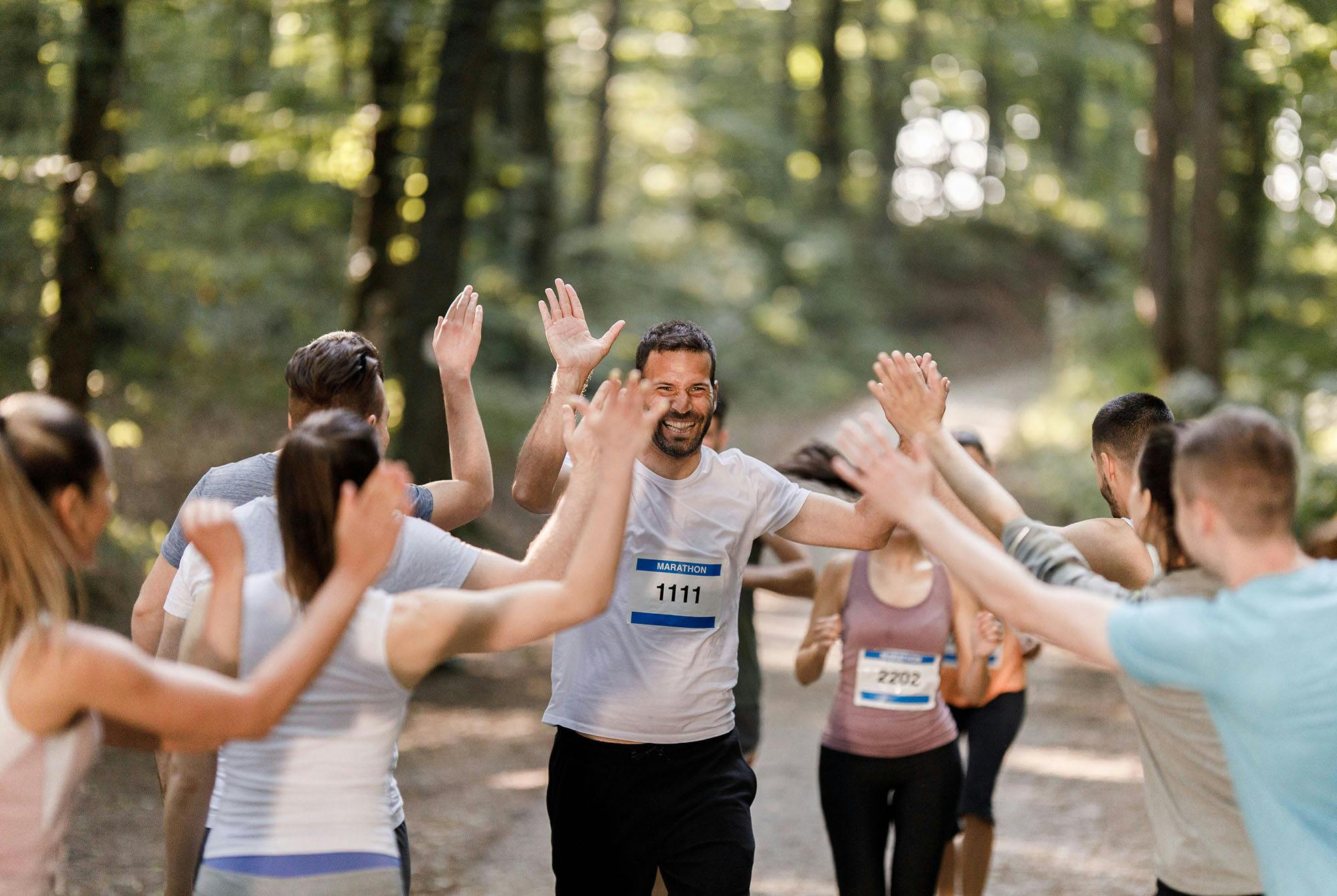Juoksutapahtuman iloisia osallistujia metsässä.