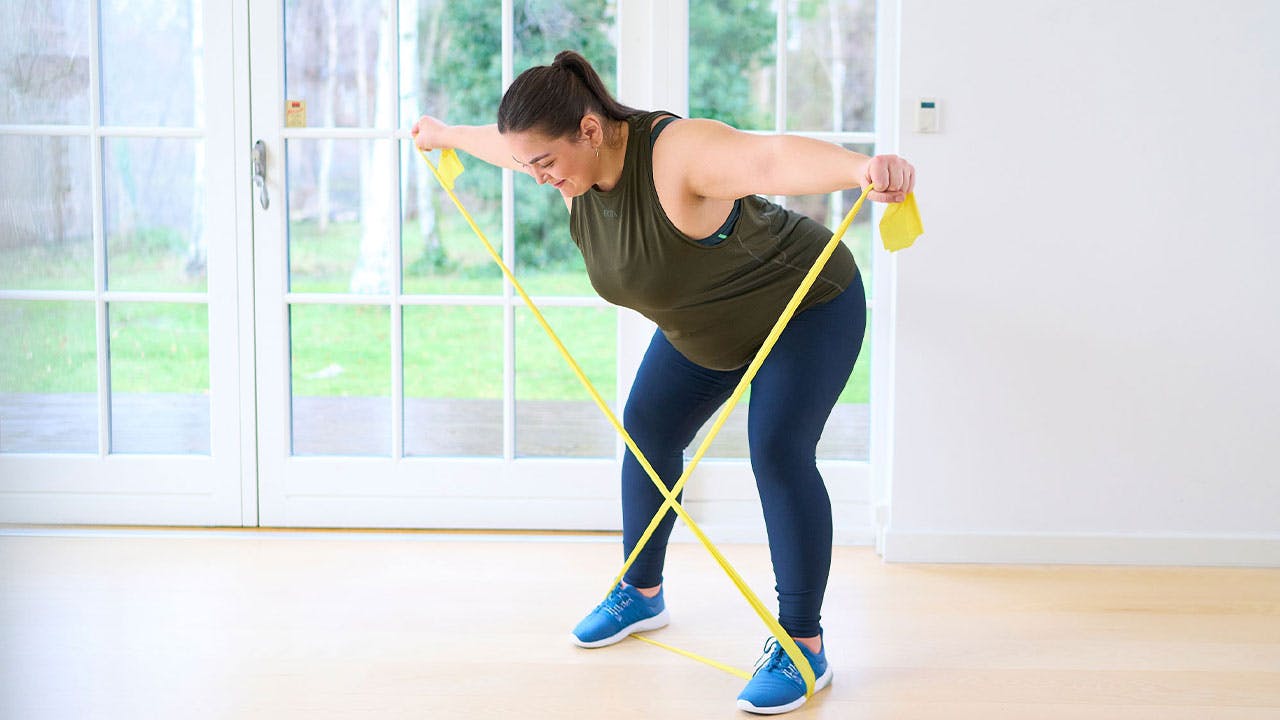 Kvinna tränar styrkeprogram för överviktiga