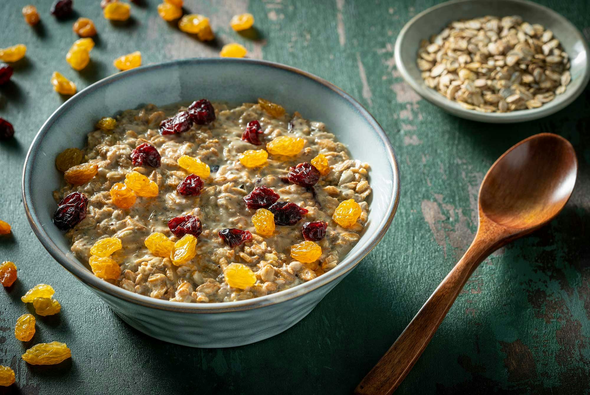 Kaurahiutaleita, kuivattuja rusinoita ja karpaloita kulhossa.