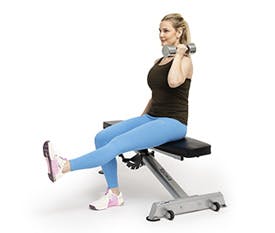 Kvinna gör pistol squat på bänk med vikter