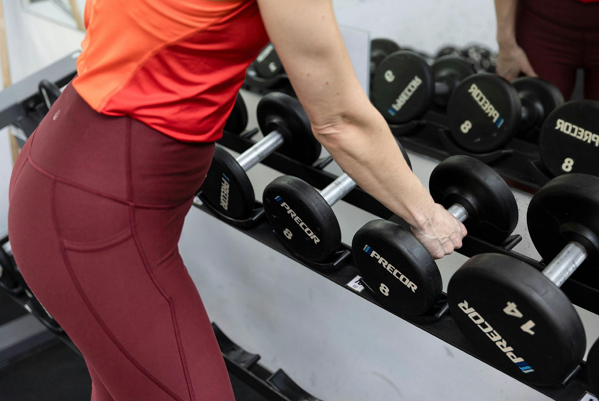 kvinne velger vekt for skulderpress