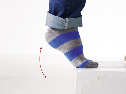 Mand med stribbede sokker strækker ud i sine akillessene