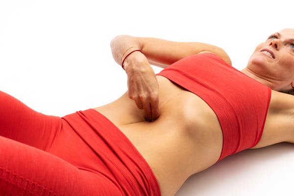 Nainen makaa lattialla ja testaa, onko hänellä vatsalihasten erkauma