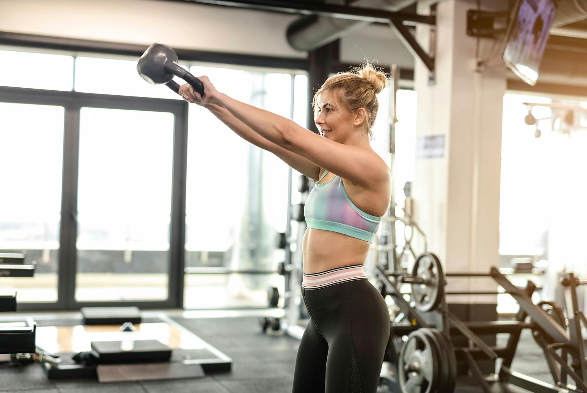 En kvinne trener med en kettlebell