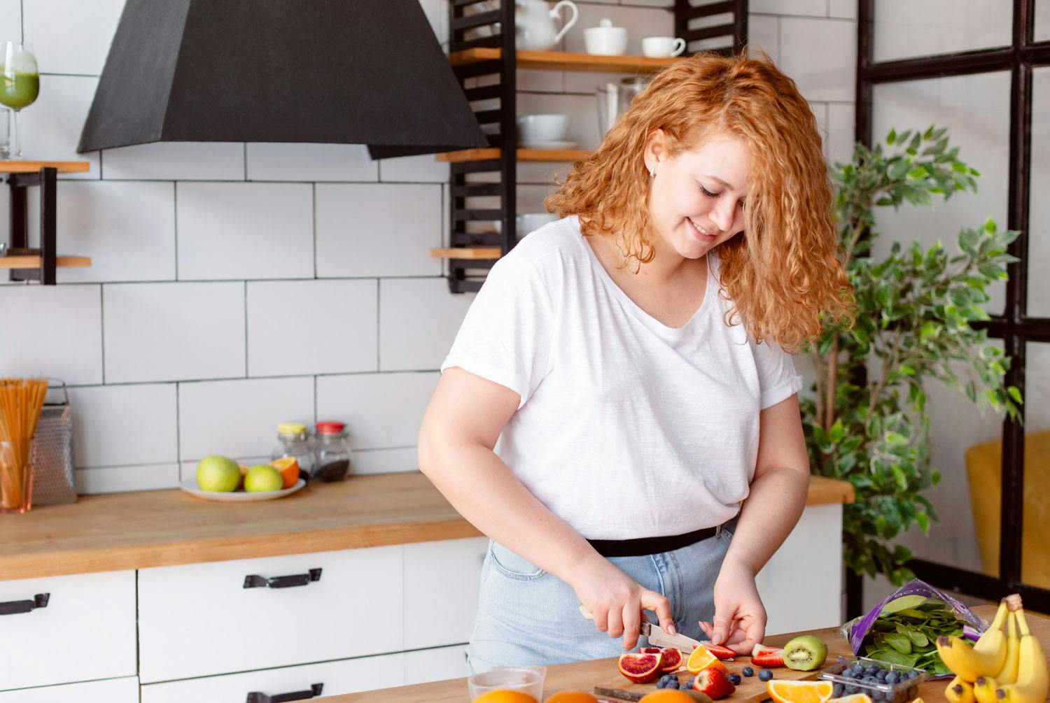 Nainen pilkkoo hedelmiä ja vihanneksia – noudattaa Ozempic-ruokavaliota