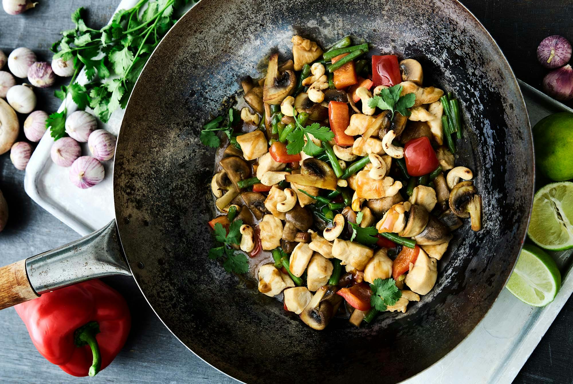 Vokki, jossa on broileria, kasviksia ja pähkinöitä.