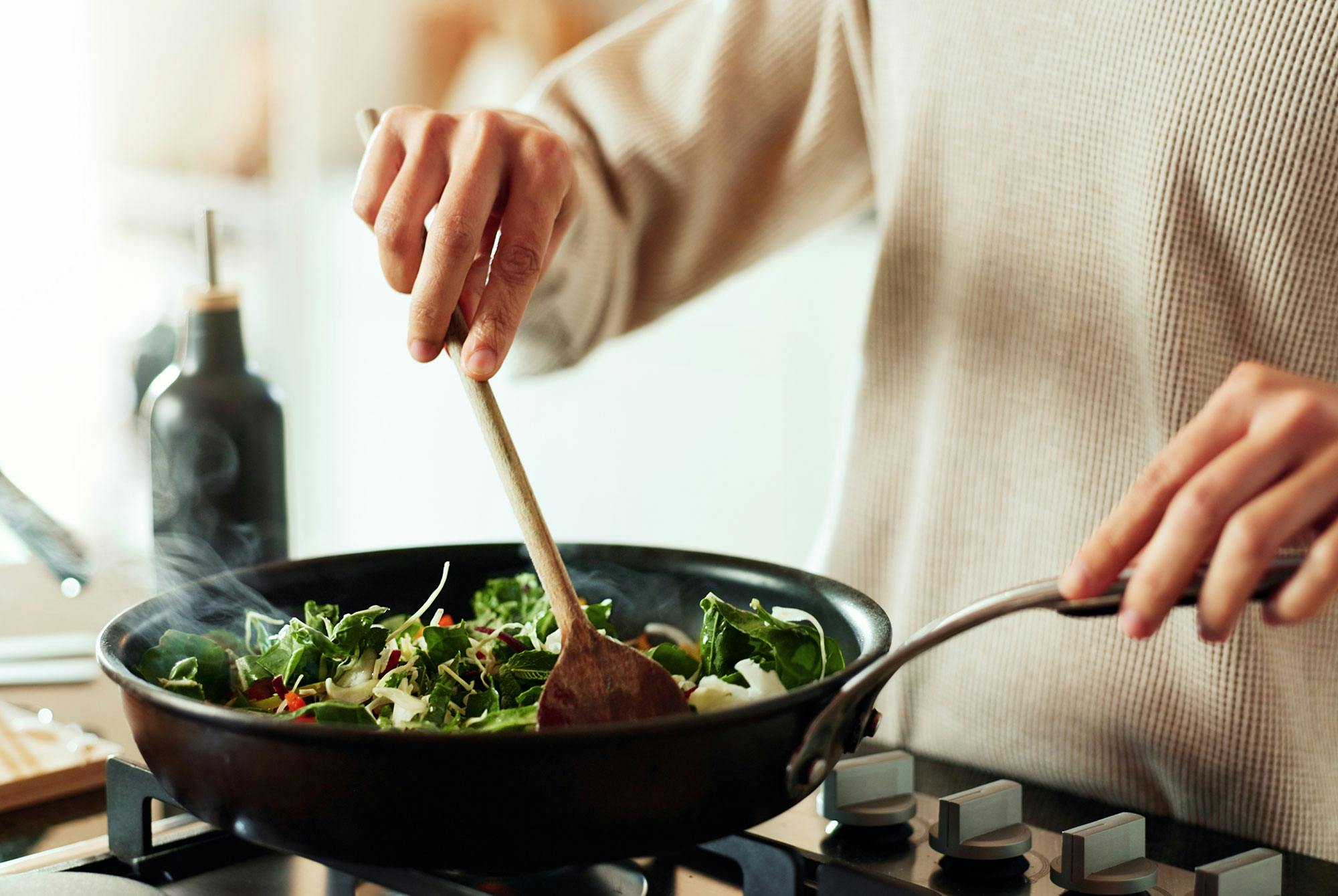 Kvinder laver wok af grøntsager.