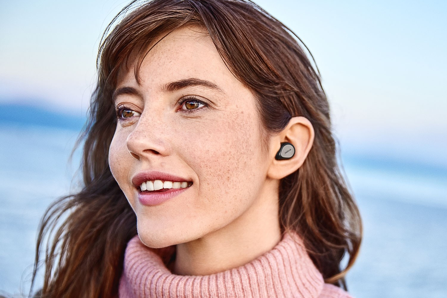 Kvinde med trådløst headset fra Jabra i øret.