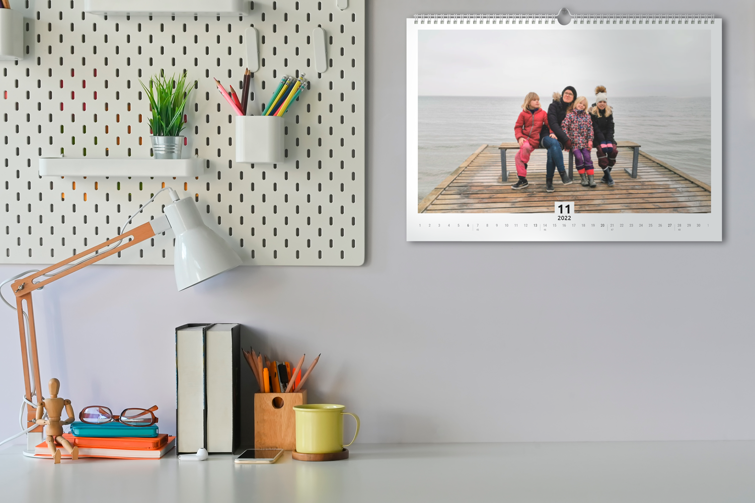 Kontorsmiljö med en fotokalender på väggen.