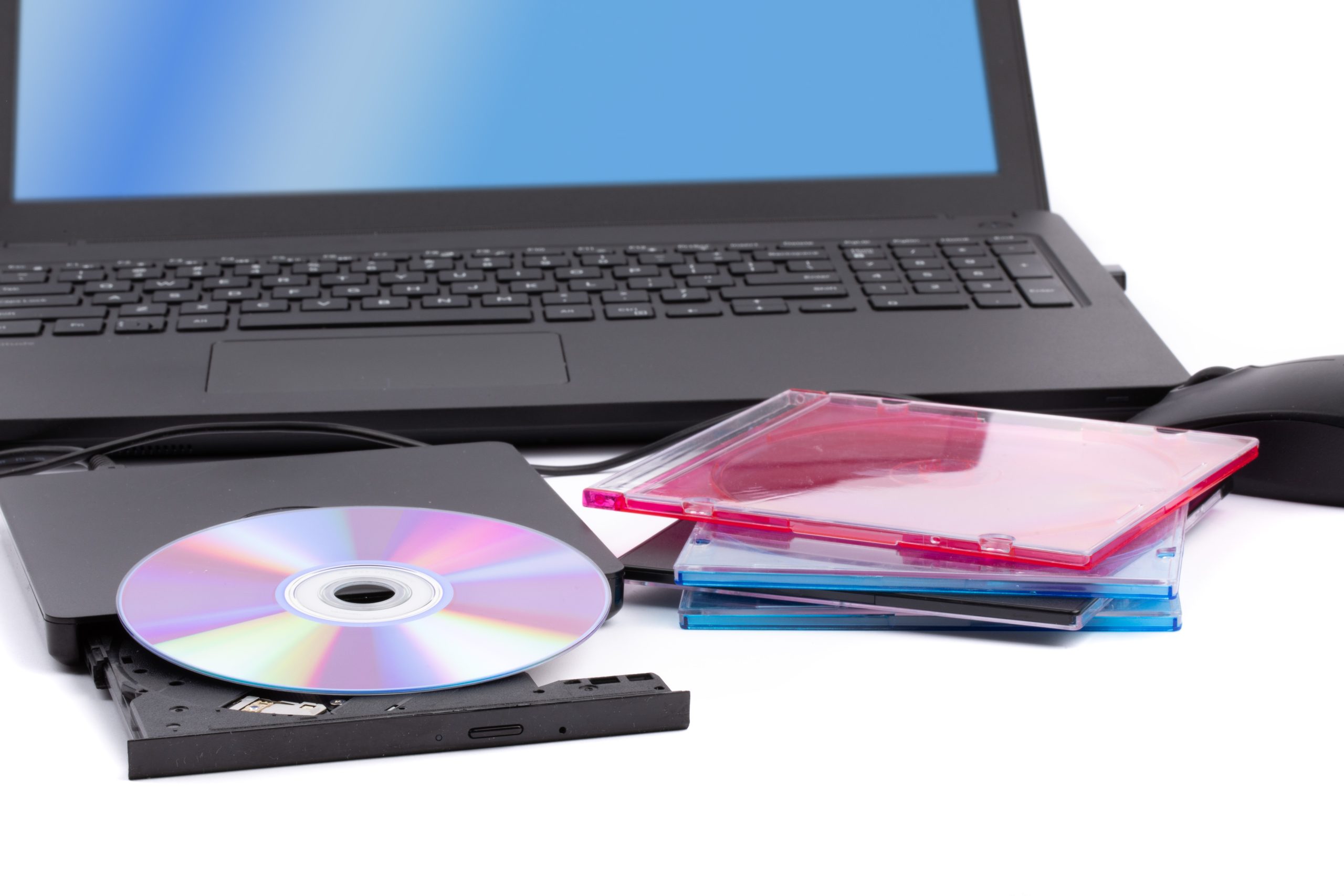 En bærbar pc med en ekstern dvd-stasjon og en dvd klar til å brenne eller spille.