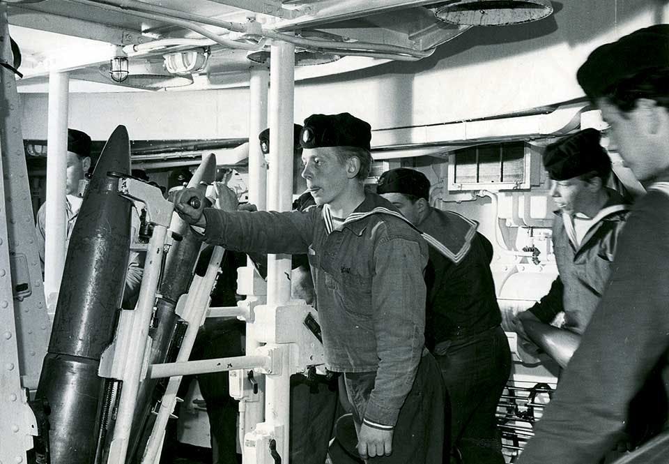 Matroser lastar granater i ammunitionshissen.