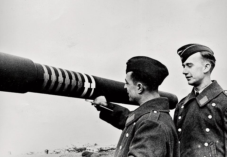 En tysk soldat målar en segermarkering på en 88:s eldrör.