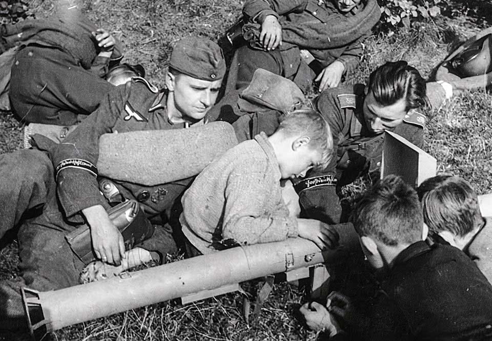 på en fältövning visar grenadjärer ur Großdeutschlands ersättningsbrigad en »panzerschreck» för några pojka på en fältövning visar grenadjärer ur Großdeutschlands ersättningsbrigad en »panzerschreck» för några pojka
