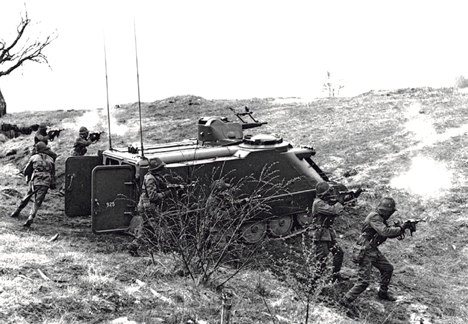 En skyttegrupp stormar ur en Pbv 302 under en övning.