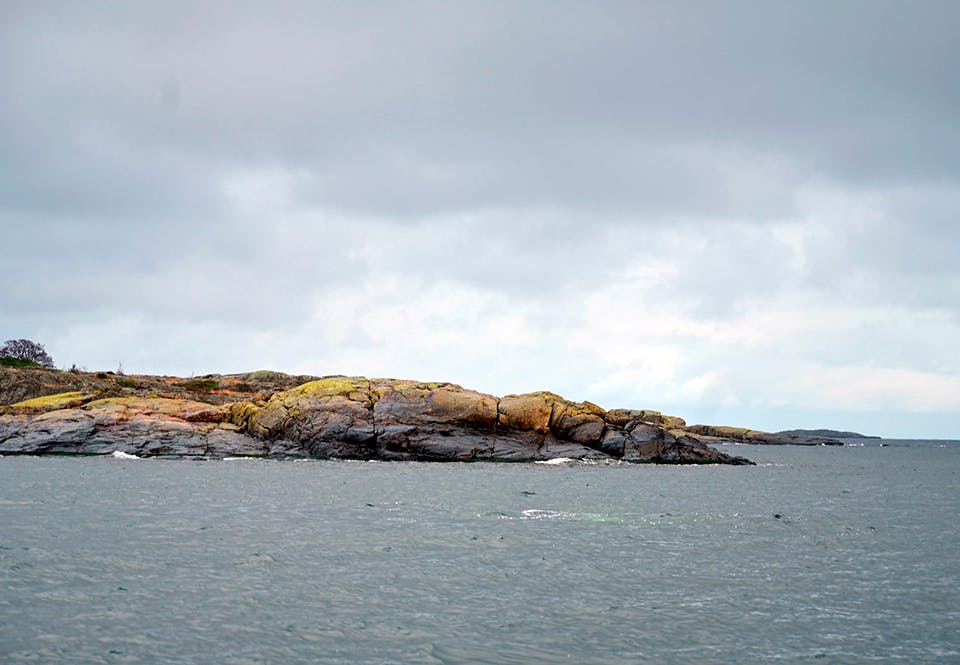 klippa klippa på en nästan plan sandbotten