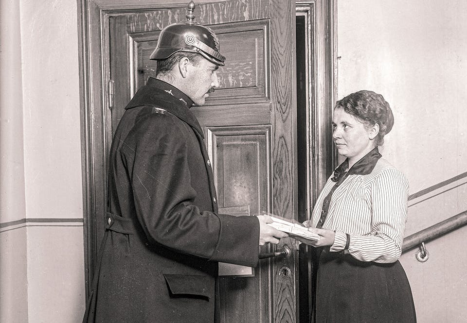 Polis i samtal med en ung kvinna i ett trapphus, tidigt 1920-tal.