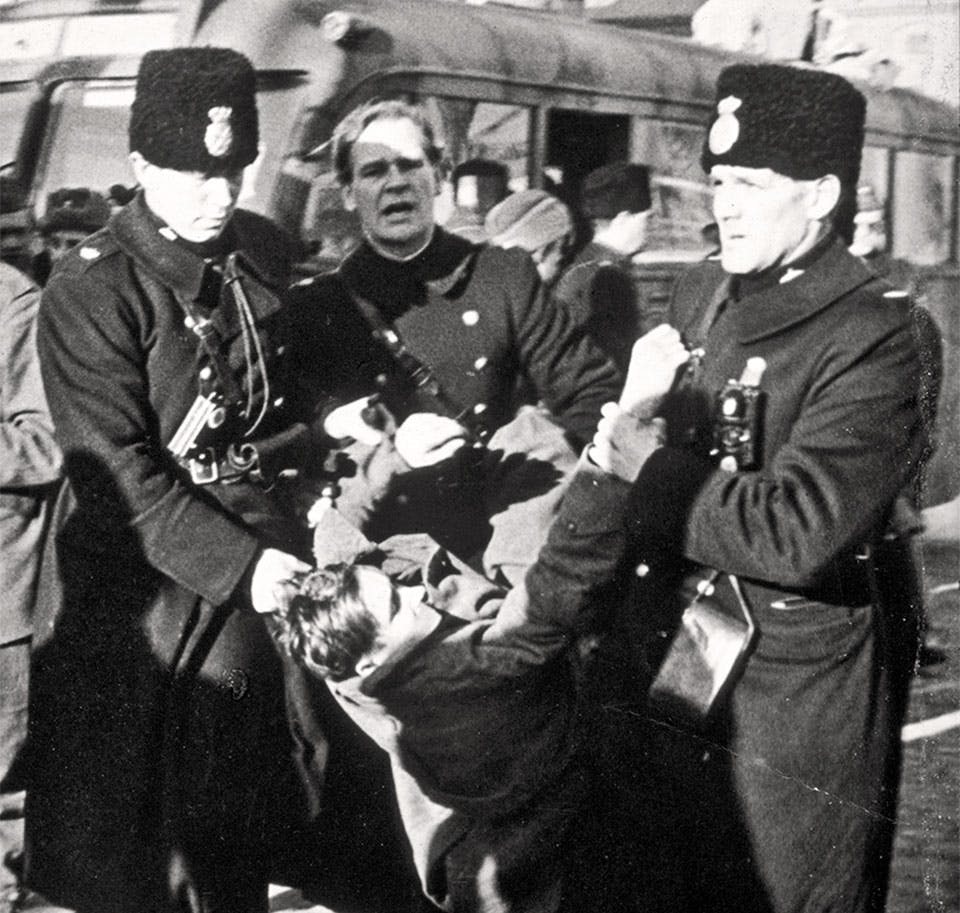 En internerad baltisk flykting släpas iväg av svensk polis för deportation. Trelleborg, januari 1946.