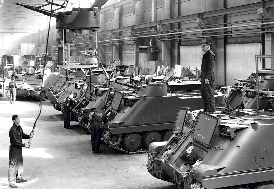 En vapenhuv till en Pbv 302 lyfts på plats för att monteras.