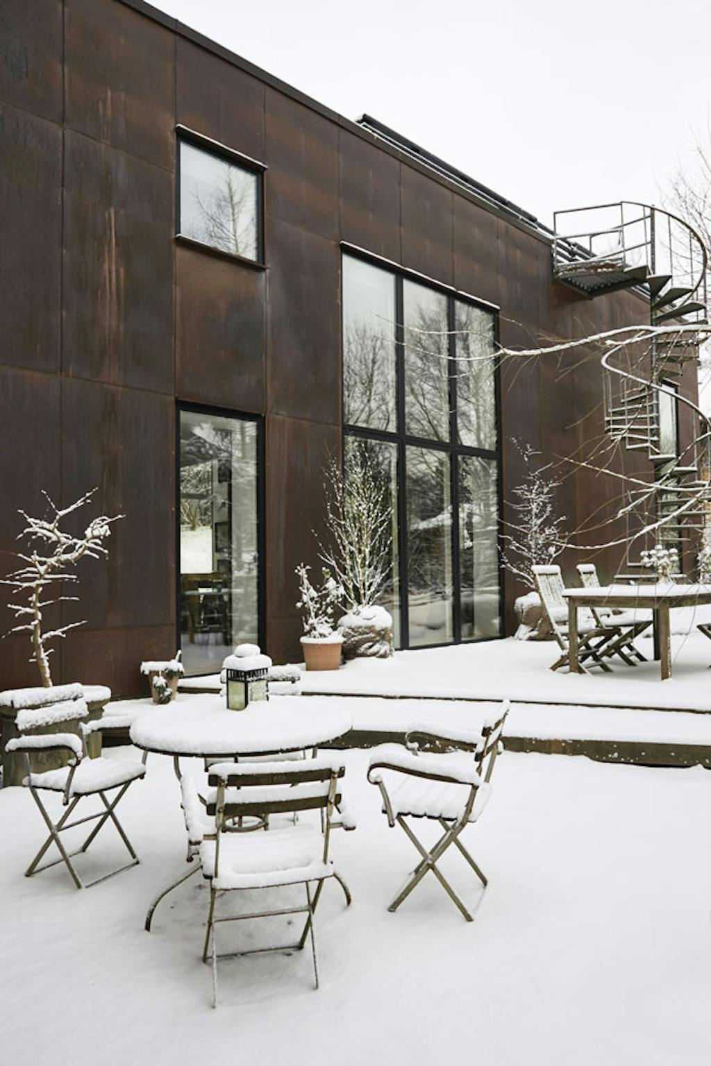 het huis is ontworpen met de oriëntatie op het bos. Dankzij de bruine kleur gaat het op in de omliggende natuur, die door de grote ramen deel uitmaakt van het interieur. 