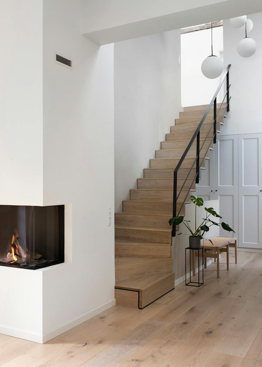 hoge entree met zwevende trap van staal en hout