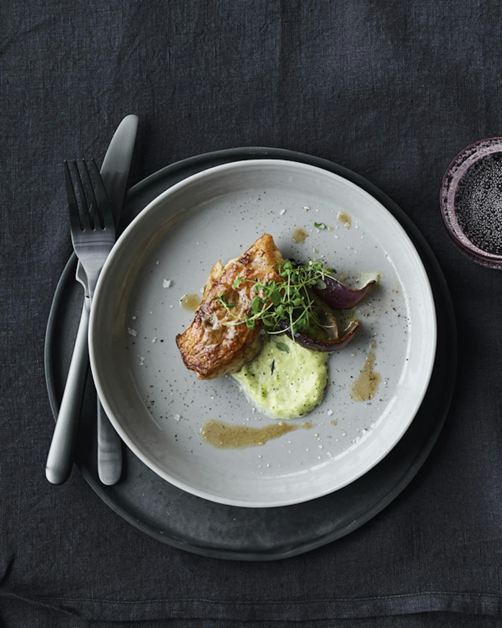 Gebakken roodbaars met preipuree en rode ui, daar wordt vrijwel iedereen blij van. Borden en schalen van handgegoten porselein van Line Rønnest.