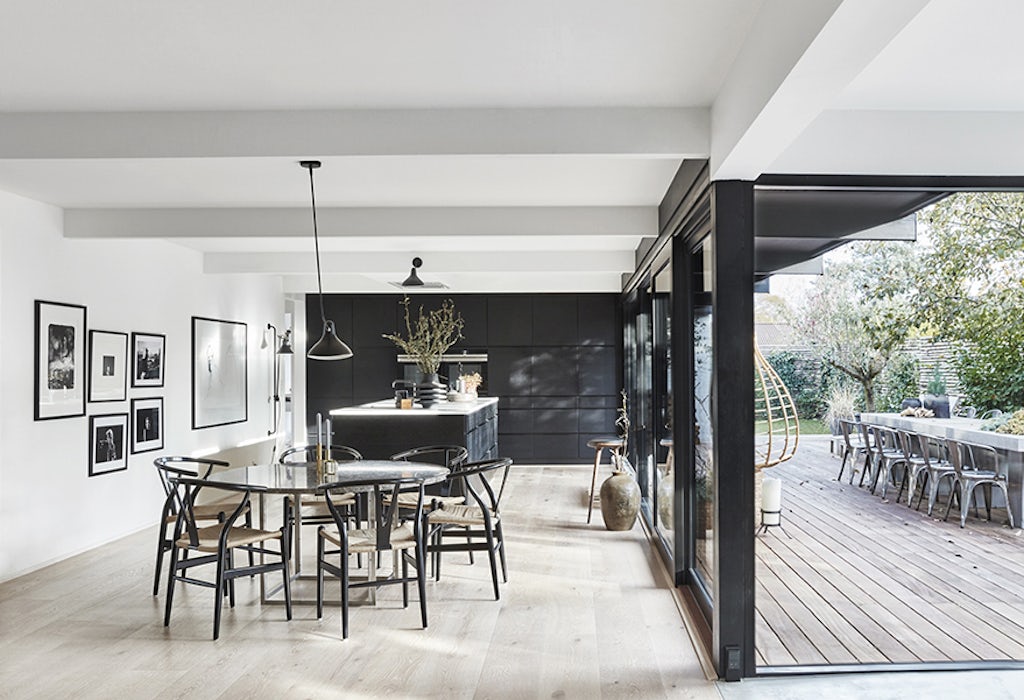 majbritt and jesper designunit 014 lead Moderne woonkamer met open keuken, houten vloer en design stoelen.