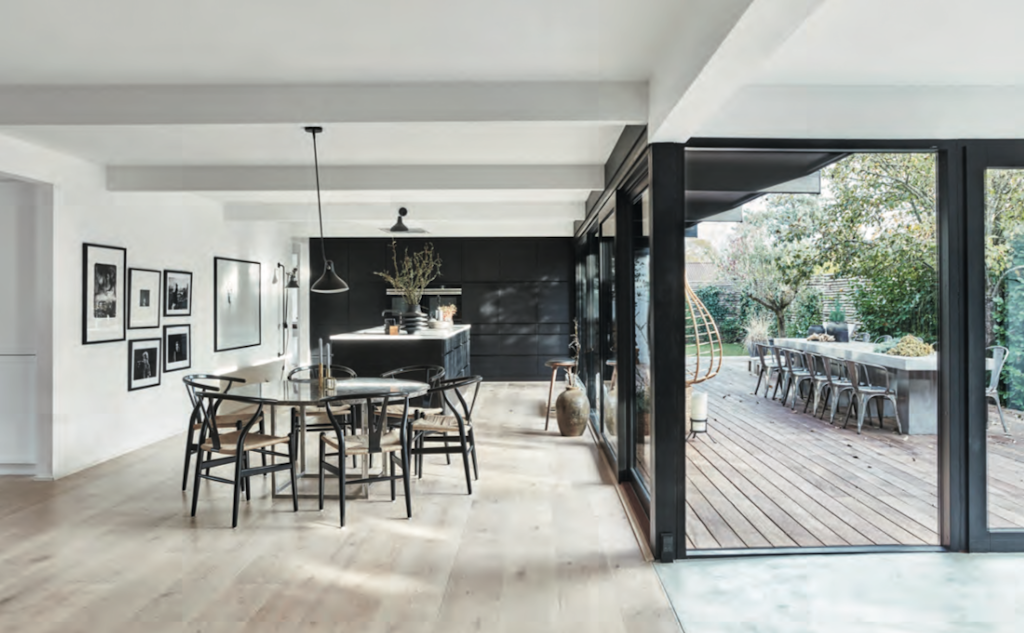 DE RONDE EETTAFEL is Poul Kjærholms PK54 met bruin marmeren blad van Fritz Hansen. Ronde eettafel, marmer blad en zwarte stoelen.