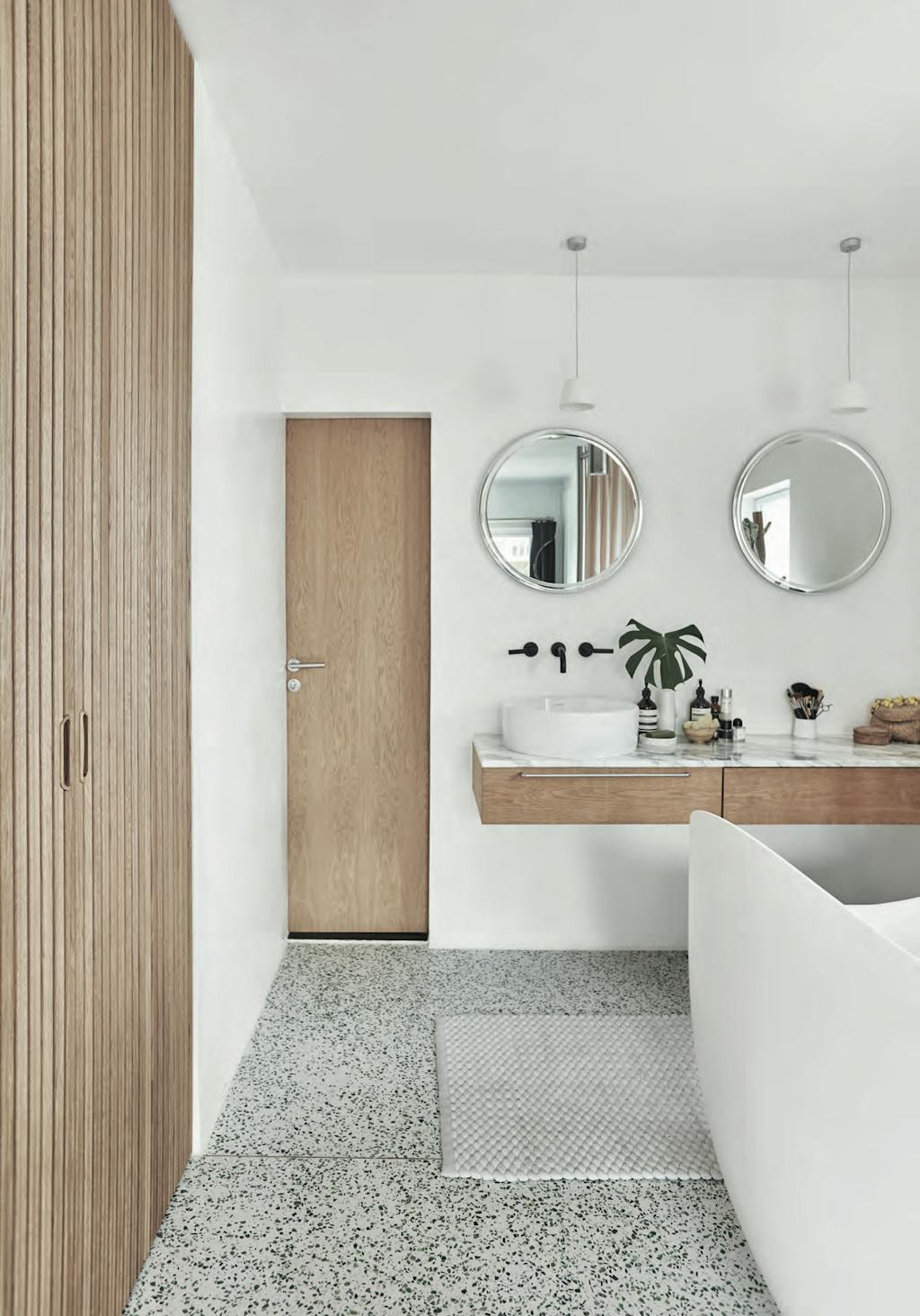 Badkamer in wit en terrazzo, met Vola kranen.