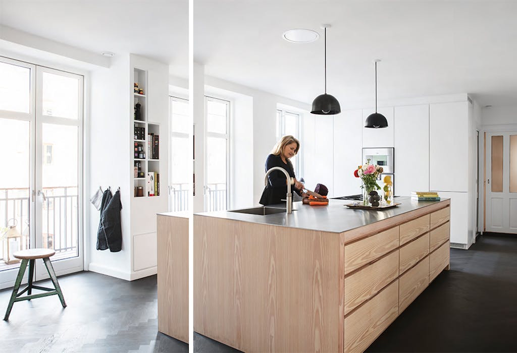 Vrouw aan Køkkensnedkeren kookeiland van grenen en staal.