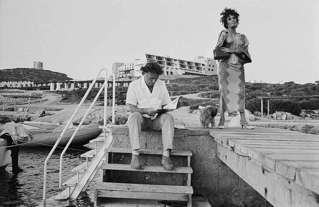 gettyimages 110692053 Elizabeth Taylor (1932–2011) iført kaftan på Sardinia under innspillingen av filmen «Boom» i 1967. Ektemann og skuespiller Richard Burton (1925–1984) sittende.