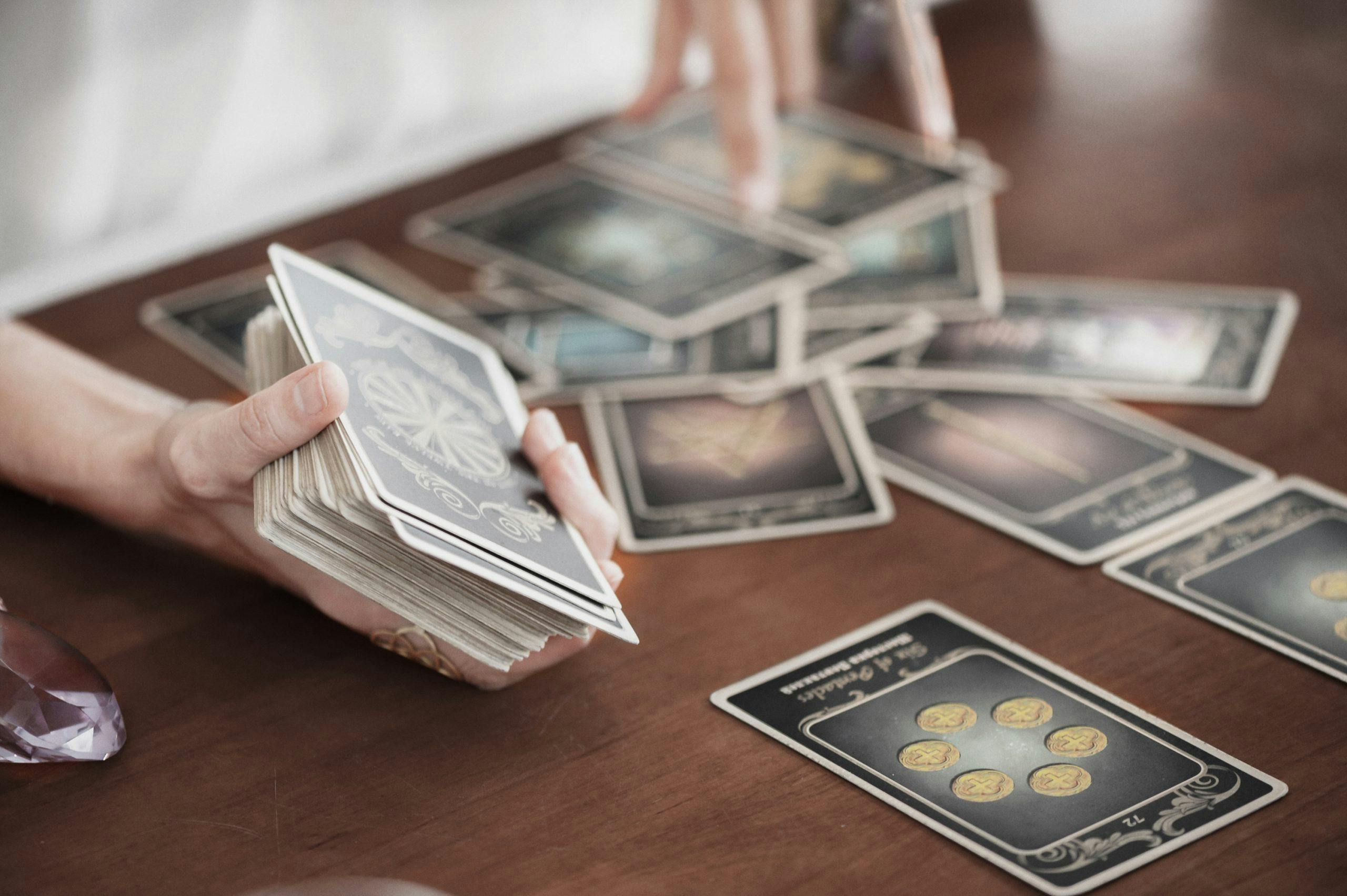 Det finnes mange forskjellige måter å legge ut tarotkort på. Kvinne legger tarotkort