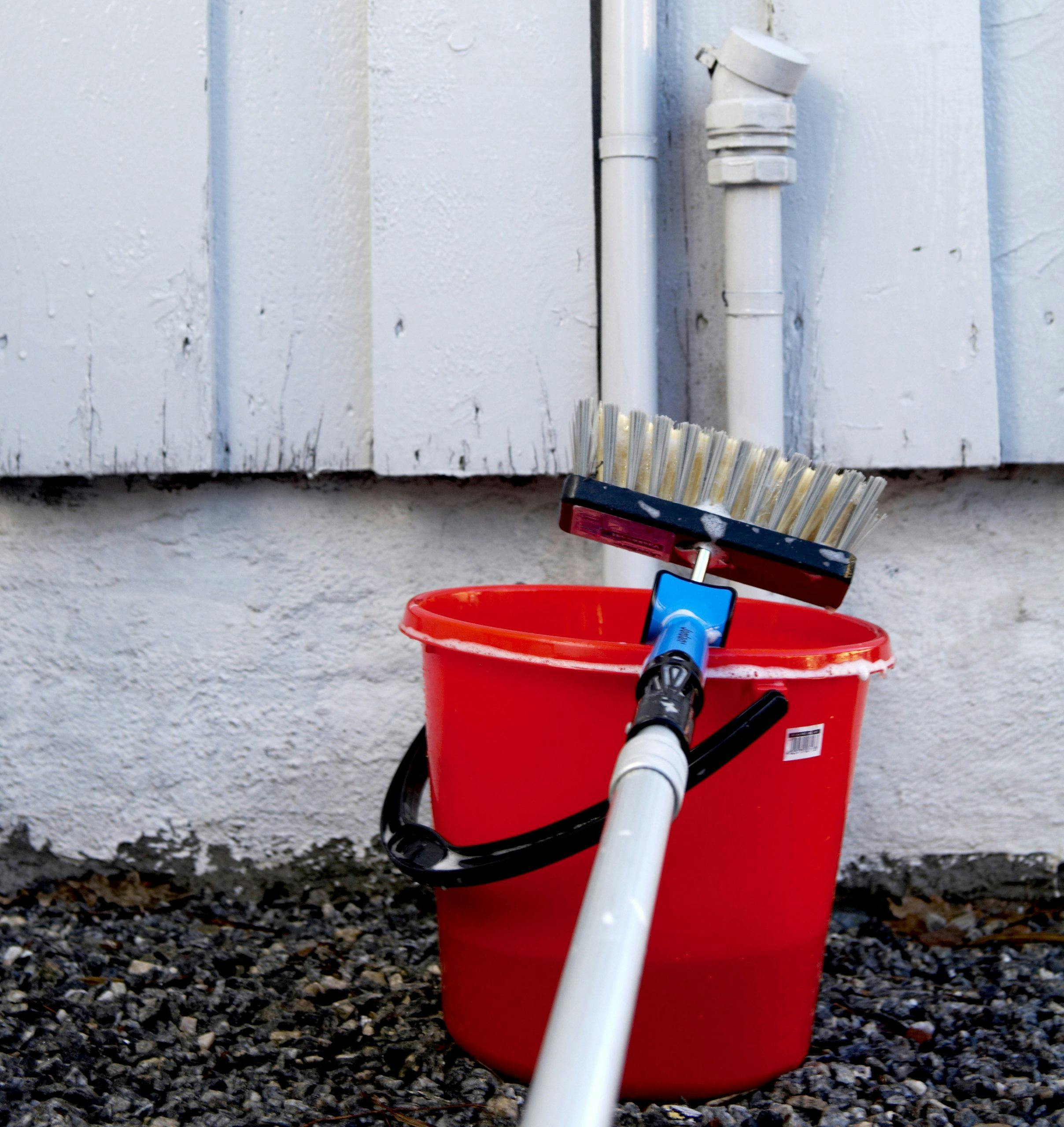 Vasking av fasade med bøtte og kost